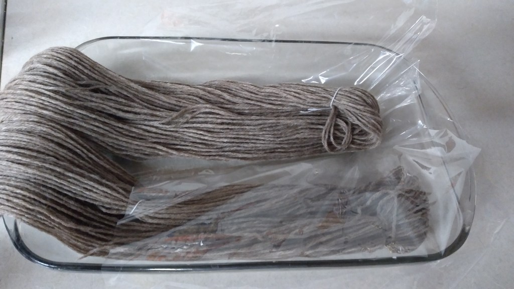 Soaked gray yarn waiting in the glass dish waiting for the dye. 